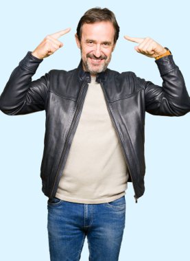 Siyah deri giyen orta yaş yakışıklı adam ceket hem el parmak, harika bir fikir ya da düşünce, iyi bellek ile baş gösteren gülen