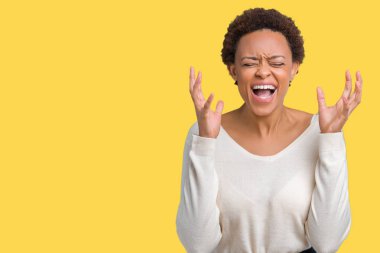 Genç Afro-Amerikan kadın yüzünden kızgın ve silah ile başarı için deli kutluyor izole arka plan ortaya çıkar ve heyecanlı çığlık gözler kapalı. Kazanan kavramı