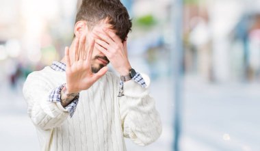 Yakışıklı delikanlı üzerinde kış kazak giyen izole elleriyle gözlerini kapsayan arka plan ve stop jest ile acı ve korku ifadesi. Utandım ve negatif kavramı.