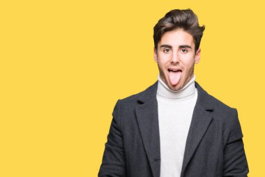 Zarif genç adam giyen kış ceket dilini izole arka plan üzerinde out komik ifade ile mutlu. Duygu kavramı.