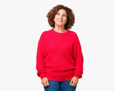 Güzel orta ager üst düzey kadın kırmızı kış kazak görünümlü yan ve dik dik bakma uzağa düşünce gülümseyen izole arka plan üzerinde.