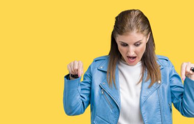 Güzel orta yaş Olgun kadın giyiyor moda deri ceket izole üzerinde arka plan işaretleme aşağı reklam, sürpriz yüz ve açık ağız gösterilen parmakları ile