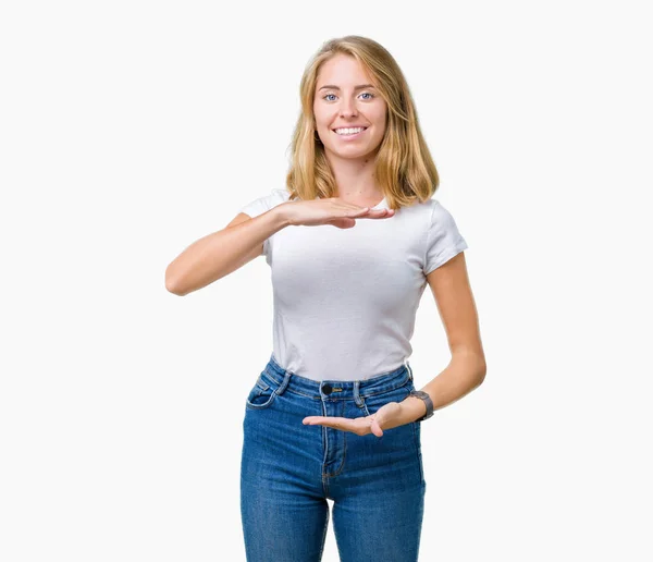 美丽的年轻女子穿着休闲的白色T恤在孤立的背景手势与双手显示大尺寸的标志 测量符号 微笑着看着相机 测量概念 — 图库照片