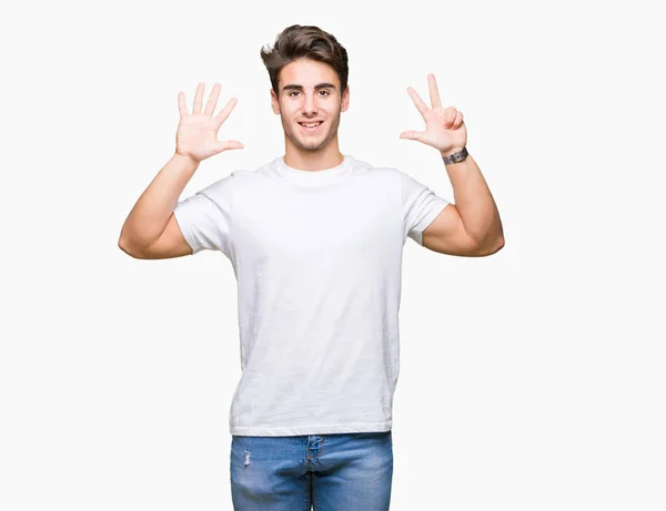 年轻英俊的男子穿着白色 T恤超过孤立的背景显示和指向八的手指 而微笑着自信和快乐 — 图库照片