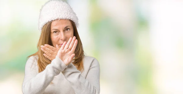 Beautiful middle age woman wearing winter sweater and hat over isolated background Rejection expression crossing arms and palms doing negative sign, angry face