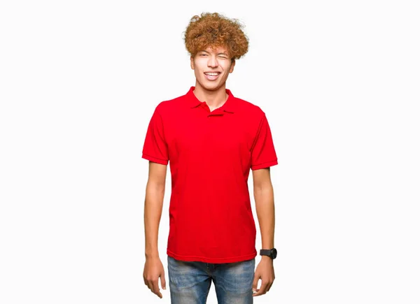 アフロ髪を着てのセクシーな表情 明るく 幸せな顔でカメラを見て赤い シャツまばたきで若いハンサムな男 — ストック写真