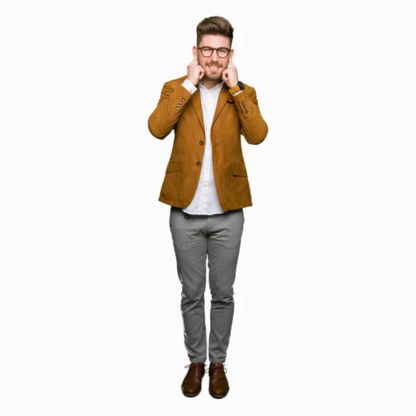 若いハンサムなビジネス男が大声で音楽の音の腹が立つ式の指で耳を覆ってメガネを着用します 聴覚障害者の概念 — ストック写真