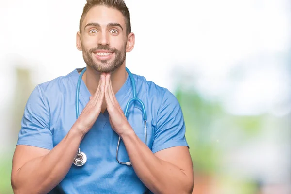 Guapo Joven Médico Cirujano Hombre Sobre Aislado Fondo Orando Con — Foto de Stock