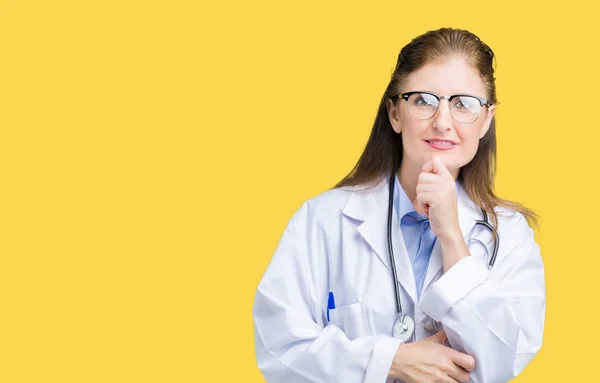 中年成熟的医生妇女穿着医疗外套在孤立的背景看起来自信的镜头与交叉的手臂和手抬起下巴自信 积极的思考 — 图库照片