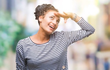 Genç örgülü saç Afro-Amerikan Kız çok mutlu ve gülümseyen uzakta el ile üzerine kafa seyir izole arka plan üzerinde kazak giyiyor. Arama kavramı.