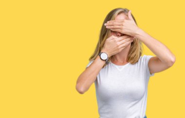 İzole arka plan kaplaması gözler ve ağız el ile üzerinden Casual beyaz t-shirt giyen güzel ve genç birbayan şaşırttı ve şok. Duygu gizleme