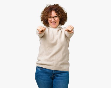 Güzel orta ager kadın kıdemli giyen boğazlı kazak ve gözlük izole üzerinde arka plan size işaret ve parmaklar, olumlu ve neşeli gülümseyen kamerayla