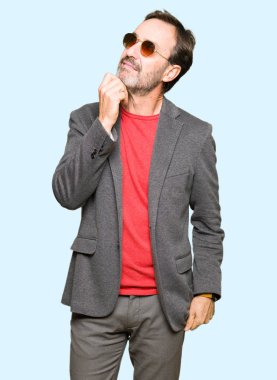 Orta çağda yakışıklı iş adamı, çenesi el ile gözlük takan soru hakkında düşünme, dalgın ifade. Düşünceli bir yüz ile gülümsüyor. Şüphe kavramı.