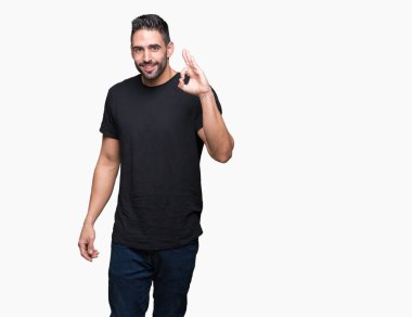 Gülümseyen izole arka plan üzerinde genç yakışıklı adam el ve parmaklar ok işaretiyle yapıyor olumlu. Başarılı ifade.