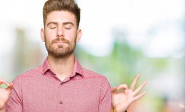 Genç yakışıklı iş Casual adam rahatlayın ve gözleri ile gülümseyen meditasyon jest parmaklar ile kapalı. Yoga konsepti.