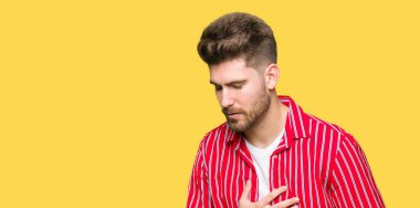 Genç yakışıklı adam mide üzerinde el ile kırmızı gömlek giyiyor çünkü hazımsızlık, ağrılı hastalık hasta hissediyor. Ağrısı kavramı.