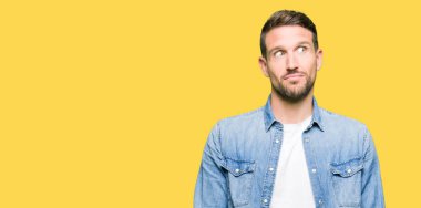 Yakışıklı adam mavi gözleri ve denim ceket görünümlü yan ve dik dik bakma uzağa düşünce gülümseyen sakal.