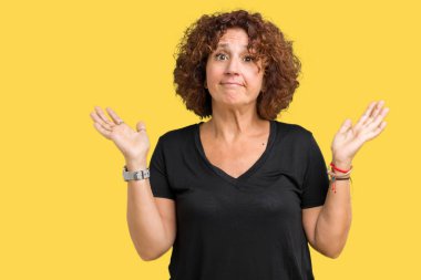 Güzel orta ager üst düzey kadın izole arka plan clueless ve şaşkın bir ifadeyle kollar ve eller kaldırdı. Şüphe kavramı.