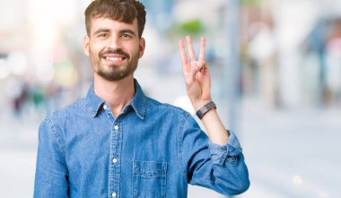 Yakışıklı delikanlı gösterilen ve parmakları ile işaret izole arka plan üzerinde üçüncü ise kendinden emin ve mutlu gülümseyerek.