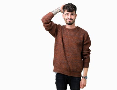 Genç yakışıklı adam giyen kış kazak izole arka plan üzerinde şaşırtmak ve soru hakkında merak ediyorum. Şüphe, kafasına el ile düşünme ile belirsiz. Dalgın kavramı.