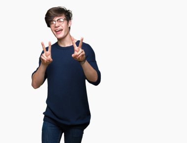 Zafer işareti yapıyor parmak gösterilen kamera seyir gülümseyen izole arka plan üzerinde gözlük takan yakışıklı delikanlı. İki numaralı.