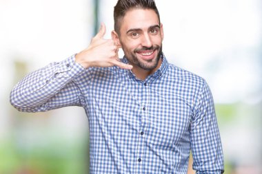 Yakışıklı delikanlı yapıyor gülümseyen izole arka plan üzerinde telefon hareketi ile el ve parmak telefonda konuşuyor gibi. Kavramları iletişim.