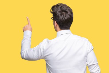 Genç iş adamı gözlük izole üzerinden geriye doğru arkasında parmak eliyle işaret Posing arka plan