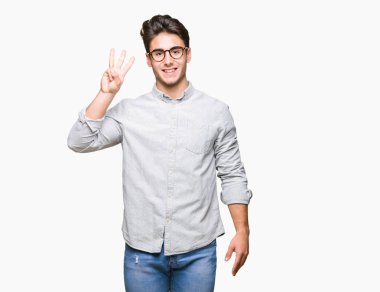 Gösterilen arka plan üzerinde gözlük takan genç yakışıklı adam izole ve parmakları ile işaret üçüncü gülümseyen ise kendinden emin ve mutlu.