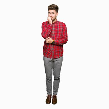 Genç yakışıklı adam stresli ve gergin elle çivi ısırma ağzına bakıyor. Anksiyete sorunu.