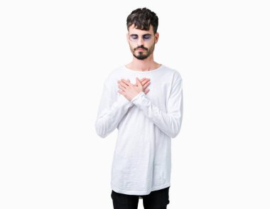 Yakışıklı delikanlı ile gülümseyen izole arka plan üzerinde güneş gözlüğü takıyor kapalı gözler ve yüzünde minnettar jest ile göğüs üzerinde eller. Sağlık kavramı.