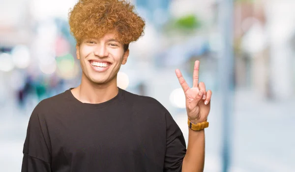 Nuori Komea Mies Jolla Afro Hiukset Yllään Musta Paita Hymyillen — kuvapankkivalokuva