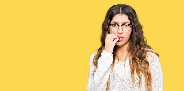 年轻的美丽的女人戴着眼镜 看上去压力很大 手放在嘴上咬指甲 焦虑问题 — 图库照片
