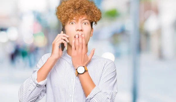 Jovem Homem Bonito Falando Boca Tampa Telefone Com Mão Chocada — Fotografia de Stock