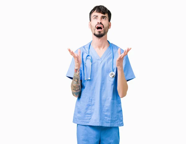 ハンサムな若い看護婦分離背景クレイジー 怒って叫んでと積極的な表現と腕を上げると叫んで経由外科医の制服を着た男 欲求不満のコンセプト — ストック写真
