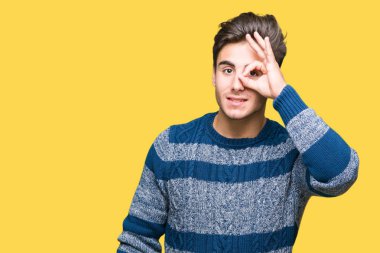 Genç yakışıklı adam gülümsüyor, parmakları ile mutlu yüz üzerinden seyir göz el ile ok jest yapıyor izole arka plan üzerinde.