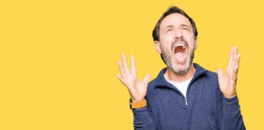 Orta yaş yakışıklı adam deli ve deli bağırarak ve agresif ifade ve silah kaldırdı bağırıyor bir kazak giyiyor. Hayal kırıklığı kavramı.