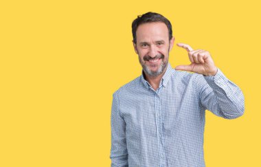 Yakışıklı orta yaş izole arka plan gülümseyen ve süre seyir ve kamera boyutu işaret parmaklarıyla yapıyor el ile kendinden emin eller üzerinde zarif komuta sizde. Ölçü kavramı.