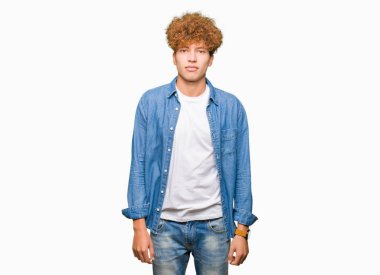 Yakışıklı genç afro saçlı kot ceket gevşek ciddi ifade ile yüzünde giyiyor. Basit ve doğal kameraya bakıyor.