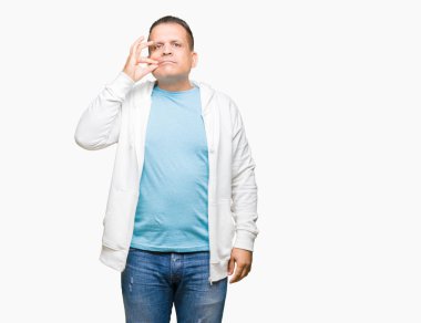Üzerinde sweatshirt giyen orta yaş Arap adam arka plan ağız izole ve parmak ile ZIP olarak Dudaklarını kapa. Gizli ve sessiz, tabu söz