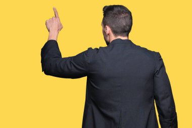 İzole arka plan üzerinde genç Hıristiyan rahip geriye parmak el ile işaret poz