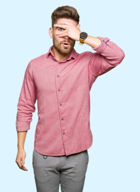 Genç yakışıklı iş Casual adam şok kapsayan yüz ve gözleri elle göz, utanmış ifade ile parmaklar bakarak.