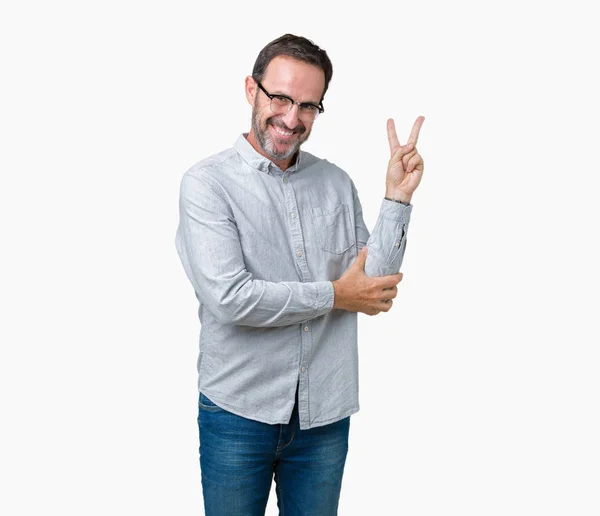 ハンサムな中年エレガント シニア男勝利のサインを行うカメラでウィンクしている幸せそうな顔を浮かべて隔離された背景にメガネを着用します — ストック写真