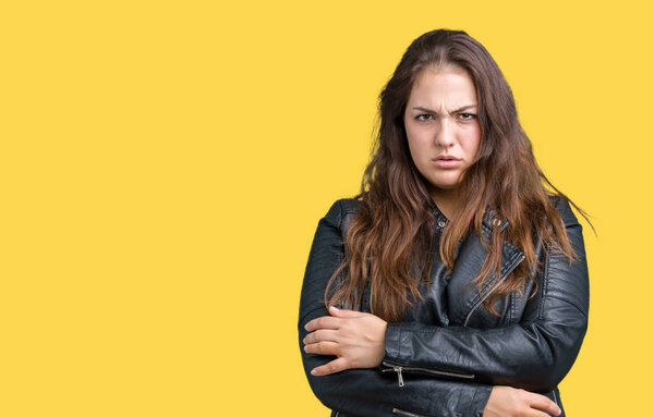 Beautiful plus size young woman wearing a fashion leather jacket over isolated background skeptic and nervous, disapproving expression on face with crossed arms. Negative person.