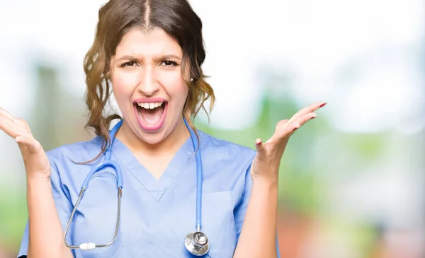 Jonge Volwassen Dokter Vrouw Dragen Medische Uniforme Vieren Gek Verbaasd — Stockfoto