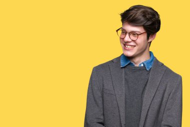 Arka plan uzak tarafına gülümseme ile yüzünde, doğal ifade seyir üzerinde gözlük takan genç yakışıklı iş adamı izole. Kendine güvenen gülüyor.