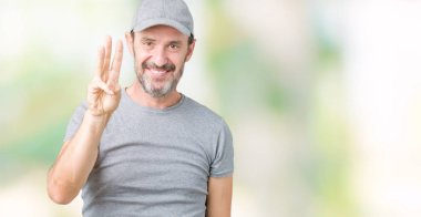 Yakışıklı orta yaş ağarmış komuta sizde Spor şapkası üzerinde gösterilen arka plan izole ve parmakları ile işaret kendinden emin ve mutlu gülümseyerek iken üçüncü.