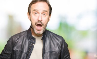 Orta yaş yakışıklı adam siyah deri ceket giyen korkmuş ve sürpriz ifade ile şok, korku ve heyecanlı yüz.