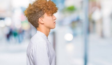 Genç yakışıklı iş adam ile afro saç giyen zarif gömlek arıyor yan, Relax profil poz doğal yüz ile emin gülümseme.