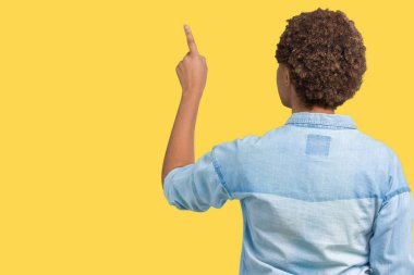Genç güzel Afrikalı-Amerikalı kadın yüzünden izole arka plan geriye doğru arkasında parmak eliyle işaret Posing