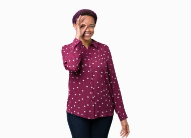 Güzel genç Afrikalı Amerikalı kadın izole arka plan üzerine baş eşarp giyen el gülümseyen ile ok jest yapıyor, göz mutlu yüz ile parmaklar görünümlü.